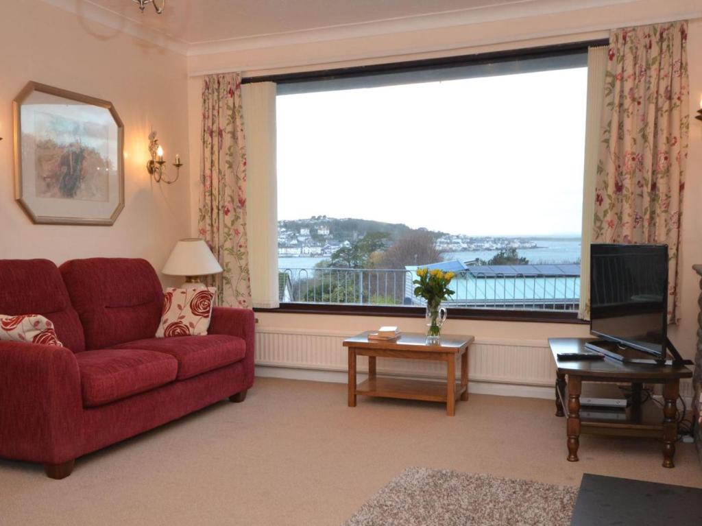 a living room with a red couch and a large window at 2 Bed in Bideford oc-sandb in Instow