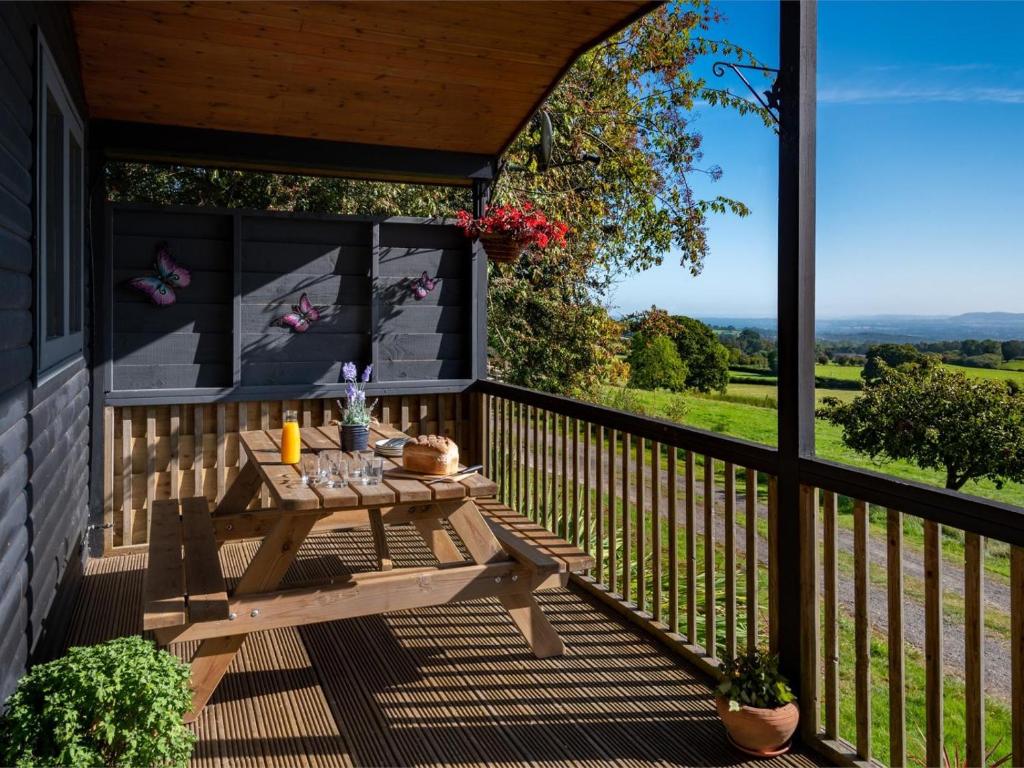 a wooden deck with a picnic table on a porch at 3 Bed in Hereford oc-bn141 in Clyro