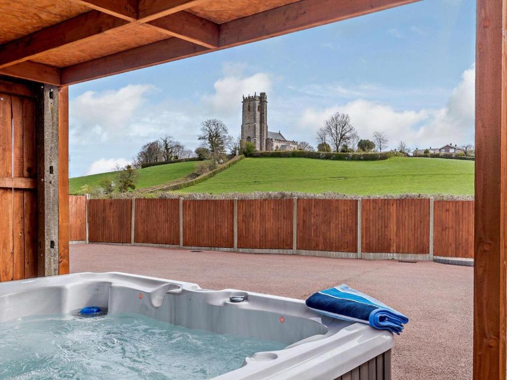 a hot tub on a patio with a castle in the background at 2 Bed in Wellington oc-00467 in West Buckland