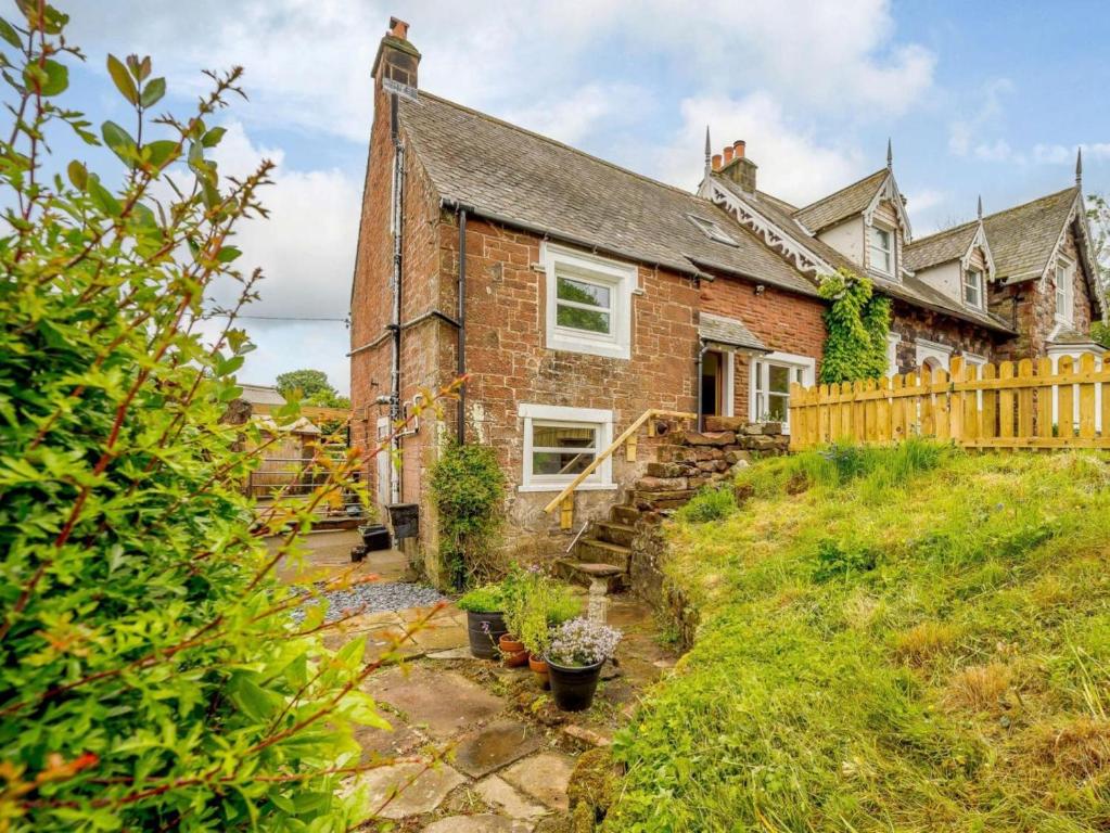 an old brick house with a wooden fence at 2 Bed in Egremont oc-87227 in Egremont