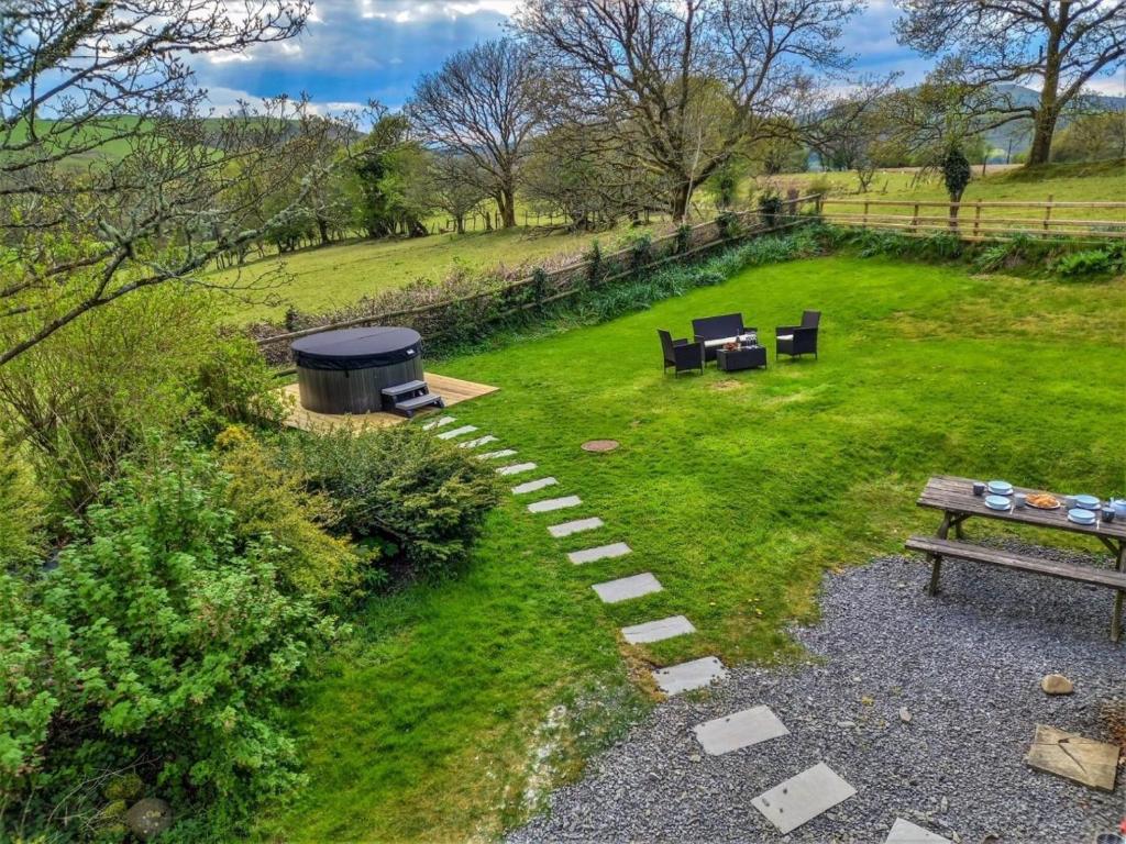 an aerial view of a backyard with a grill and a bench at 4 Bed in Llandovery oc-82440 in Llanfair-ar-y-bryn