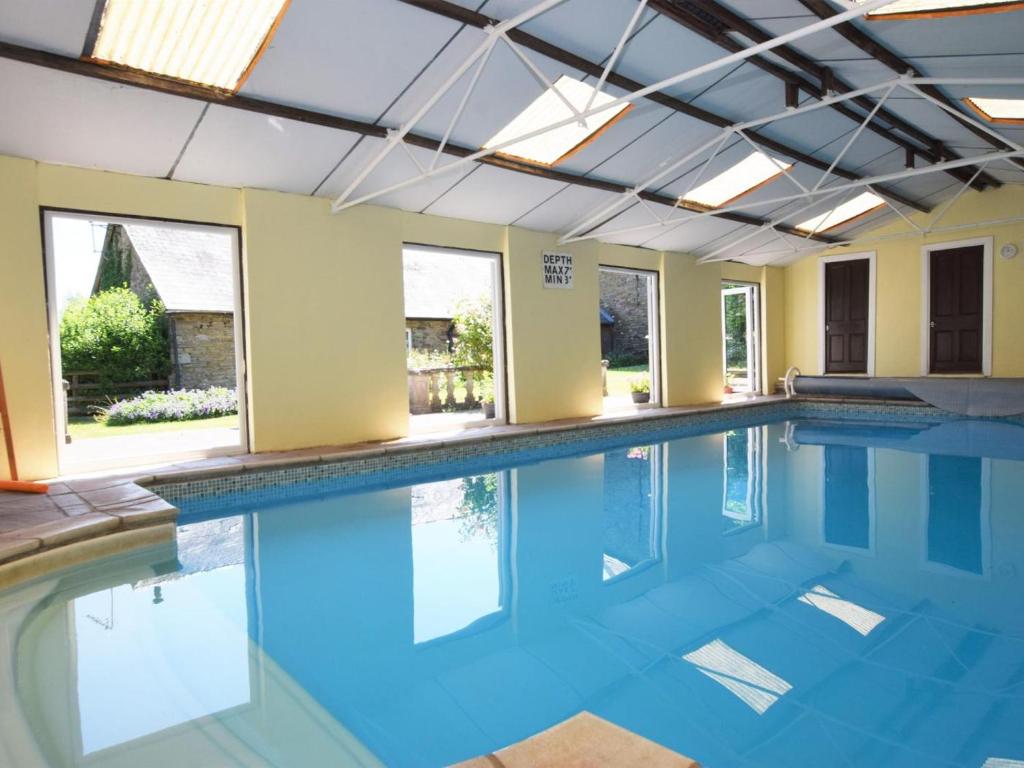 an indoor swimming pool with blue water at 2 Bed in Abergavenny oc-90235 in Llanvetherine