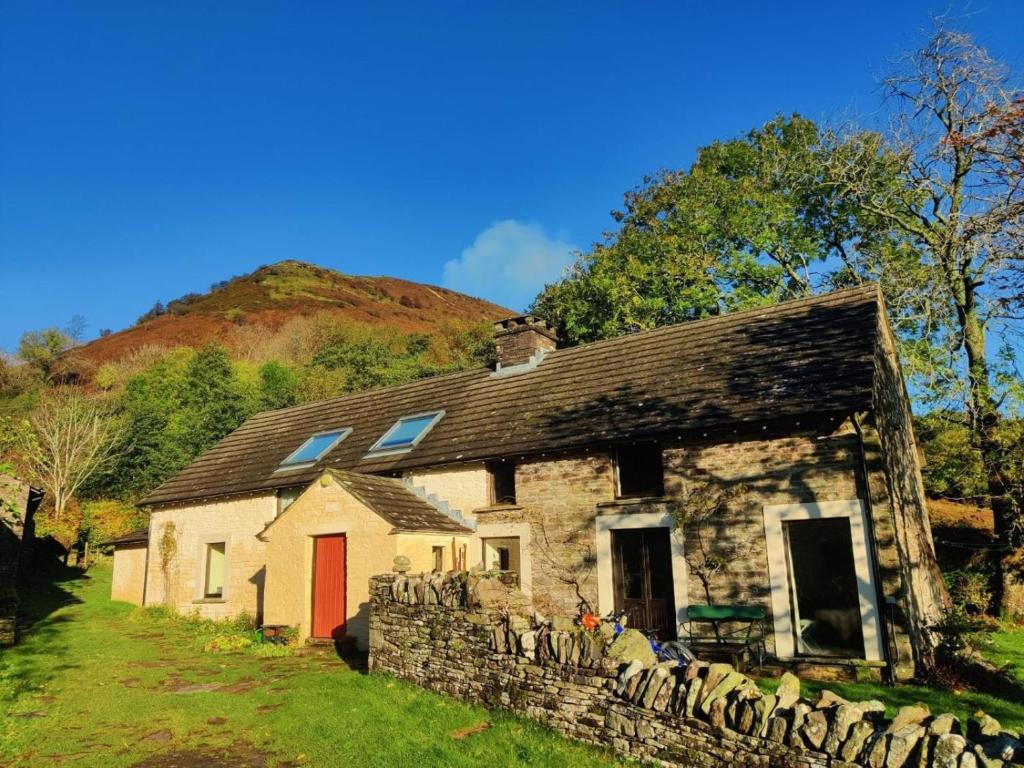 an old stone house with a red door at 3 Bed in Abergavenny oc-93362 in Capel-y-ffin