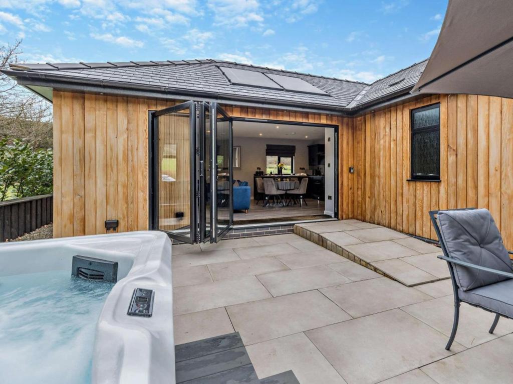 a hot tub on a patio with a house at 2 Bed in Knighton oc-94202 in Knighton