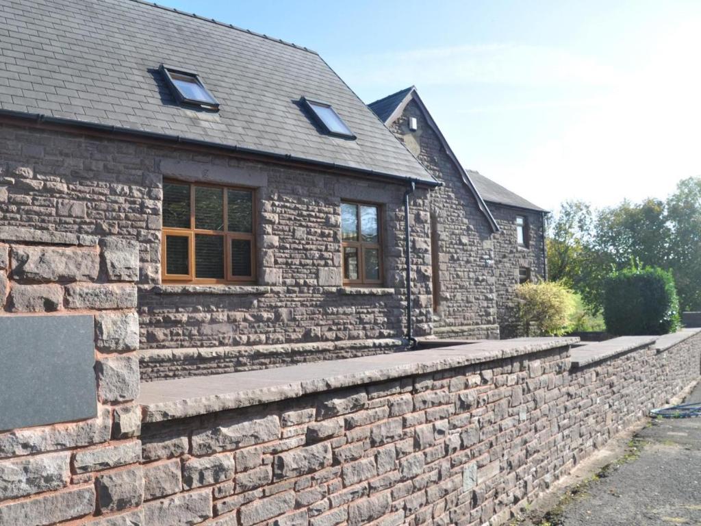a brick house with a stone retaining wall at 2 Bed in Abergavenny oc-65965 in Pandy