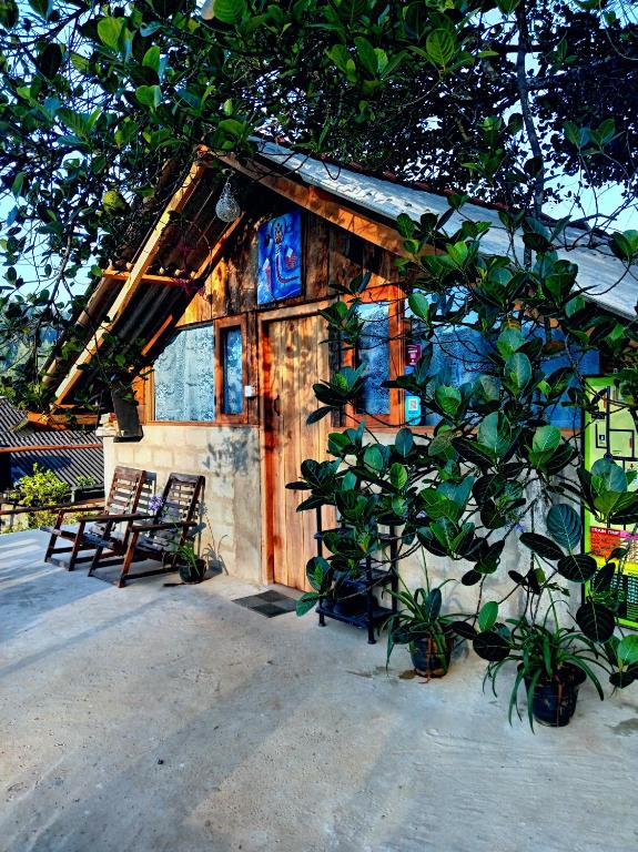 a small house with two chairs and a tree at Backpackers Hostel in Ella