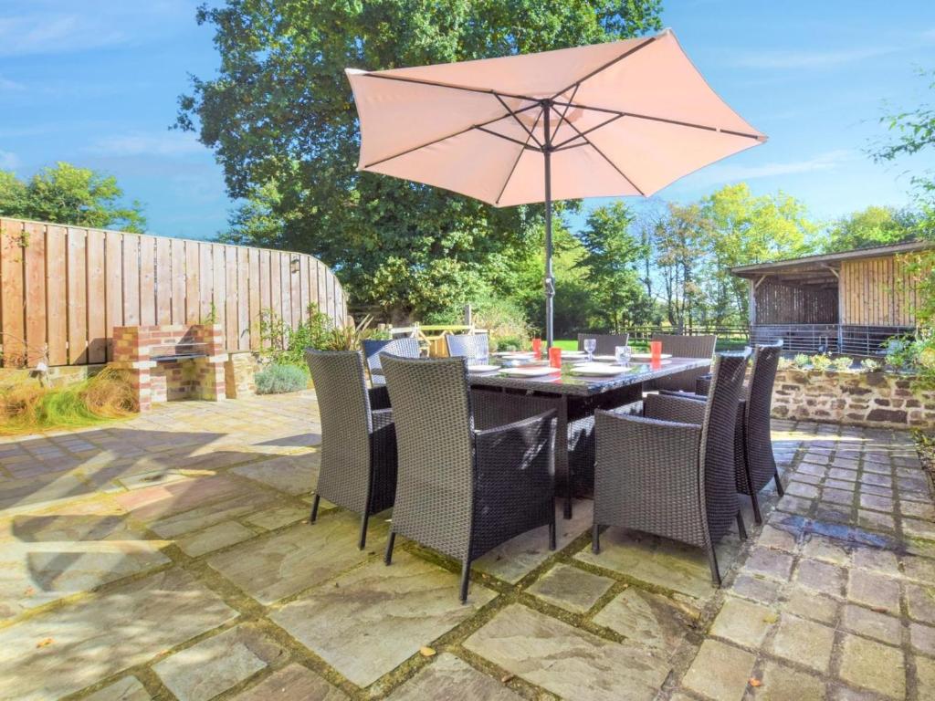 a table and chairs with an umbrella on a patio at 3 Bed in North Tawton oc-66043 in Winkleigh