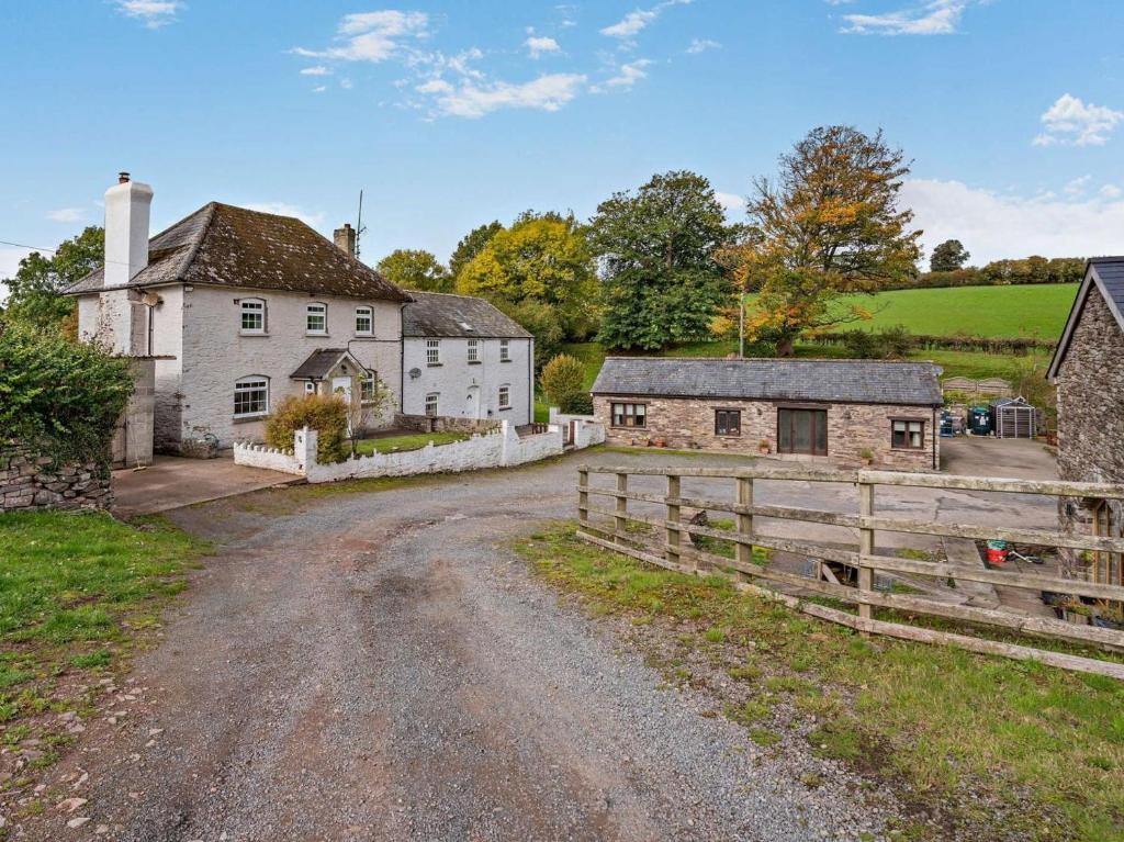 an old farm house and a fence on a dirt road at 3 Bed in Brecon oc-96240 in Llandefaelogfâch