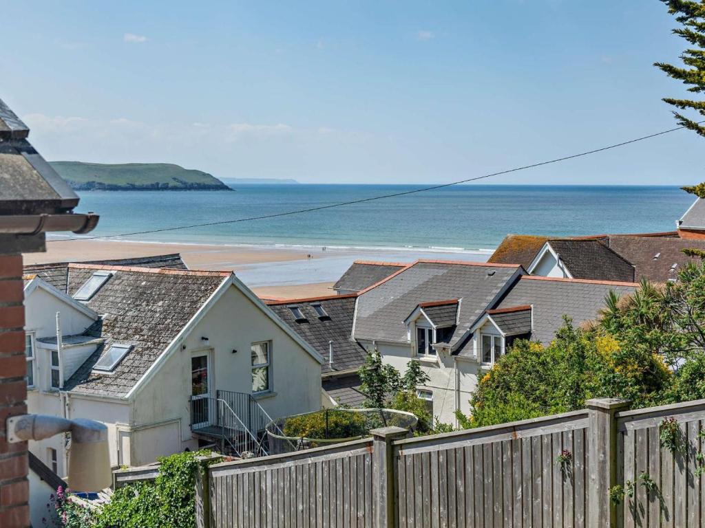a row of houses with the beach in the background at 2 Bed in Woolacombe oc-bkers in Woolacombe