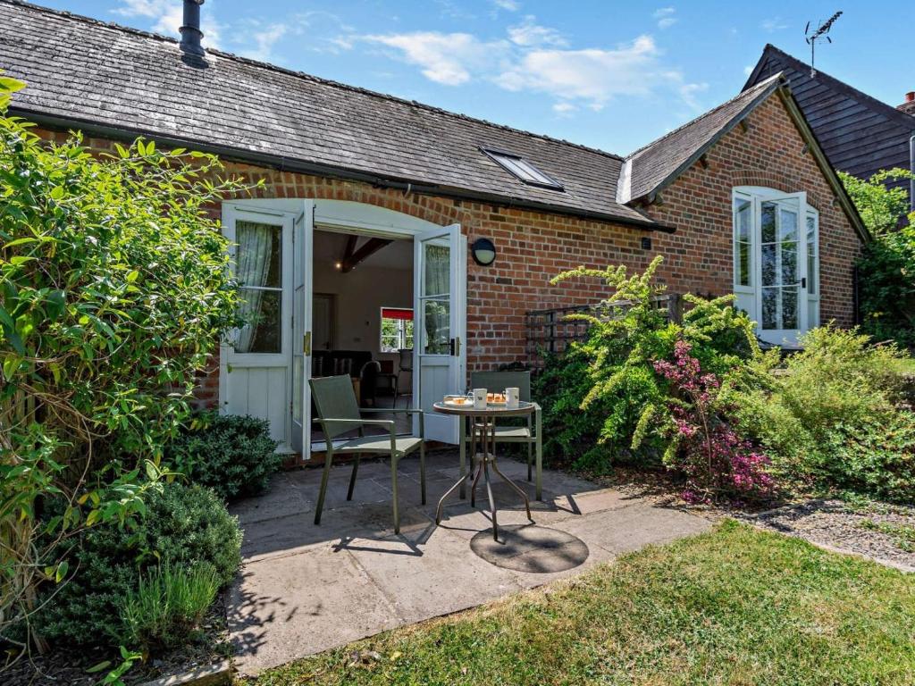 a small brick house with a table and chairs at 1 Bed in Craven Arms oc-54928 in Clungunford