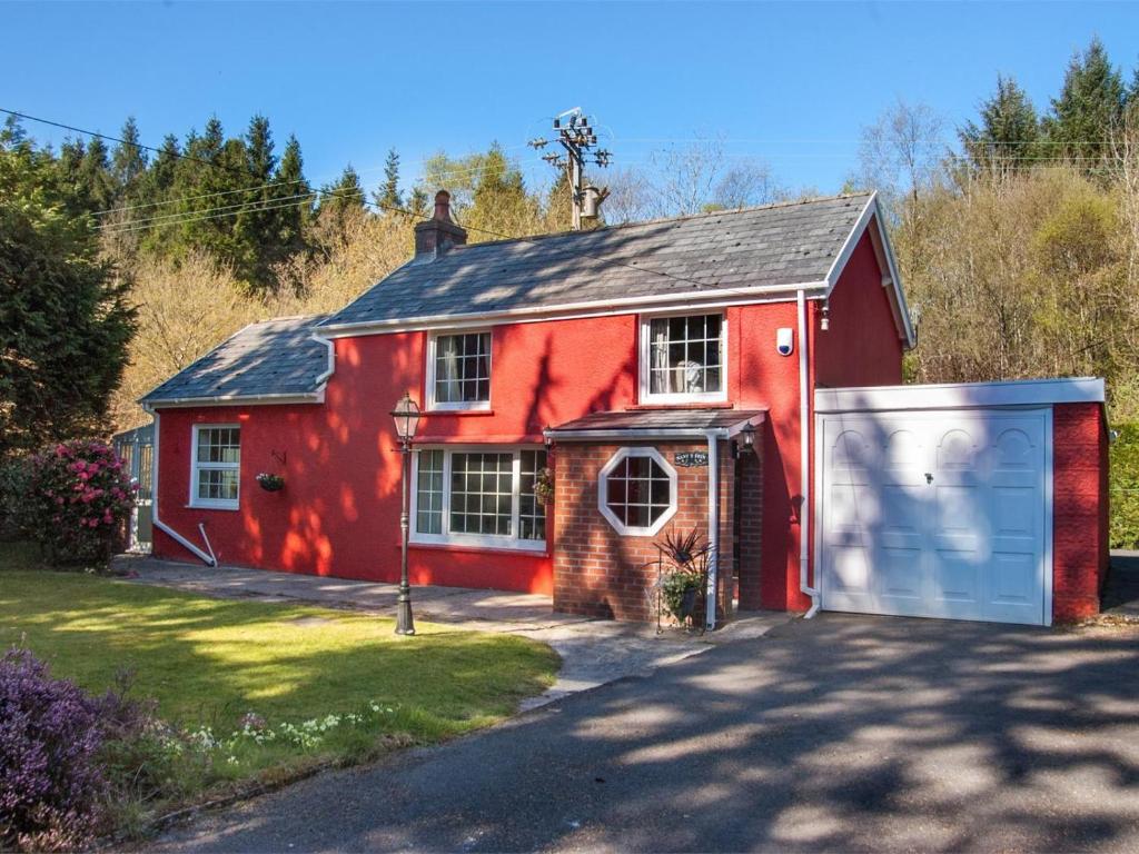 a red house with a garage in front of it at 2 Bed in Neath oc-bn247 in Crynant