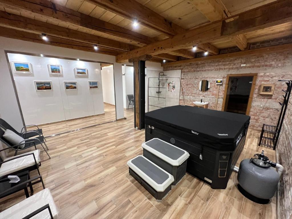 a room with a black piano in a room with wooden floors at Tejmalom Szálló in Sárrétudvari