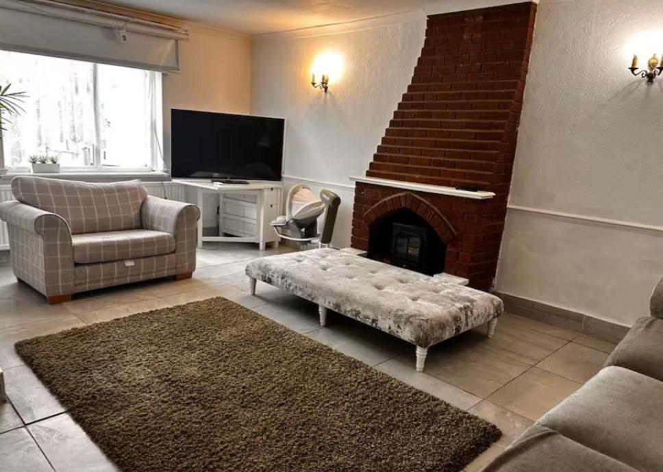 a living room with a couch and a fireplace at 5 Bedroom house Doncaster in Balby