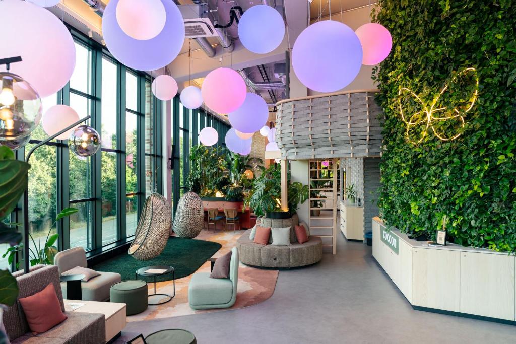 un hall d'entrée avec des ballons roses suspendus au plafond dans l'établissement Cocoon München Theresienwiese, à Munich