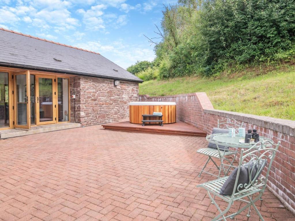 a patio with a table and chairs next to a building at 3 Bed in Brecon oc-92320 in Llandeilor-Fan