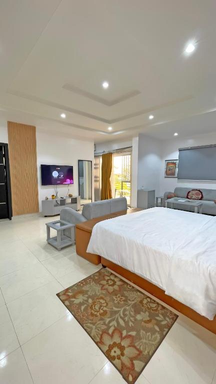 a bedroom with a large bed and a living room at 3Apartments in Lagos