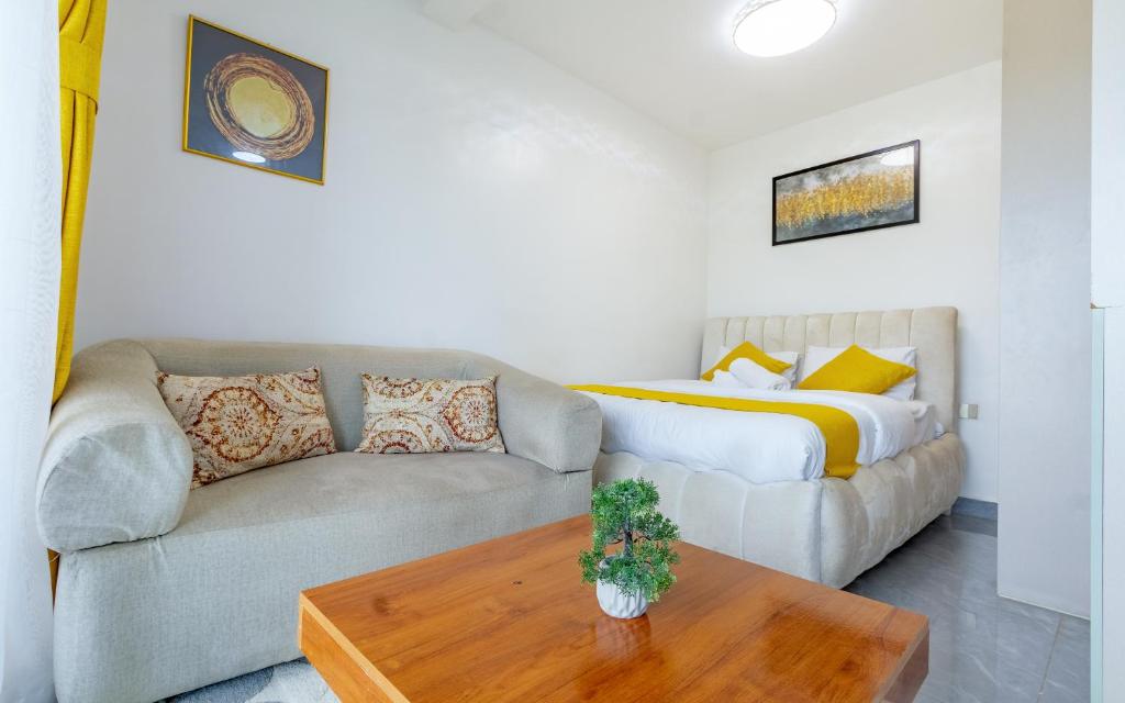 a living room with a couch and a bed at The Nestle & The Cradle - Kileleshwa in Nairobi