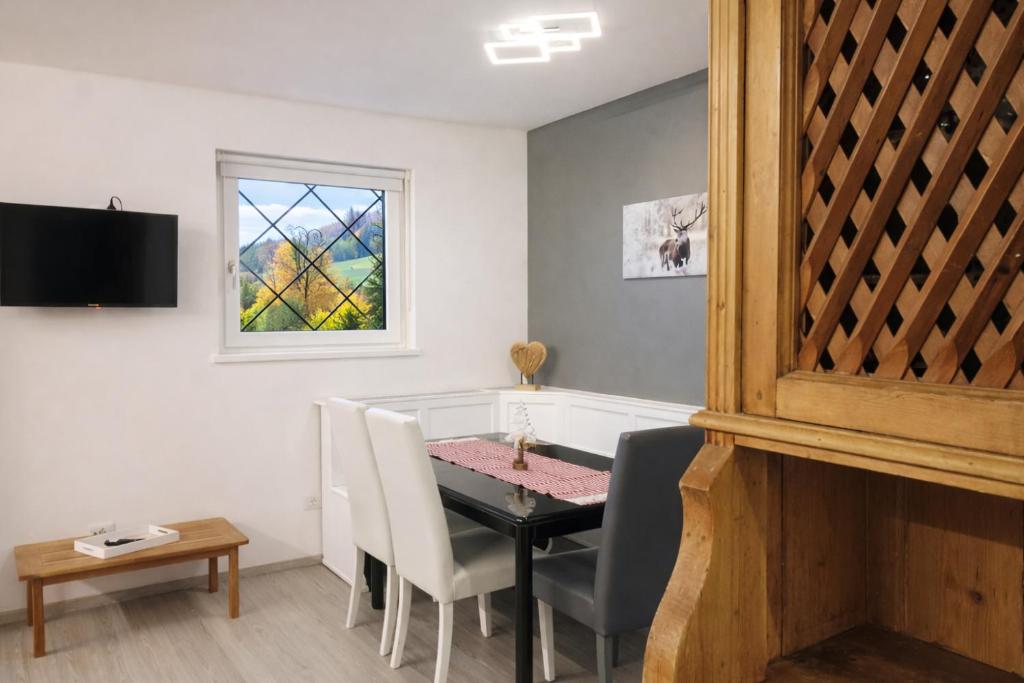 a dining room with a table and a bath tub at CASA 4 PIOPPI - Vista Lagorai e tranquillità a Cavalese - Dolomiti Affitti in Cavalese