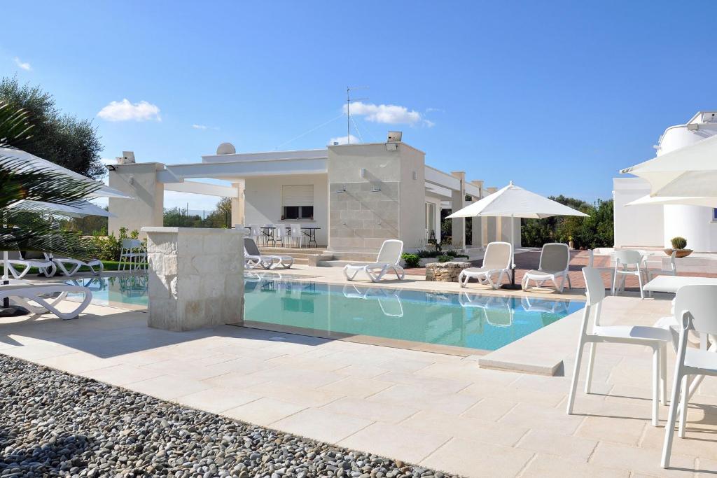 a villa with a swimming pool in front of a house at Villa Luce Relax by Perle di Puglia in Villa Castelli
