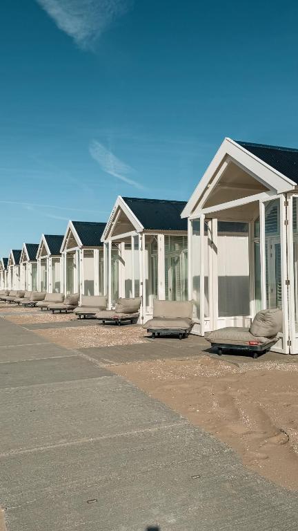 a row of white houses sitting in a parking lot at SandCsleep in Katwijk