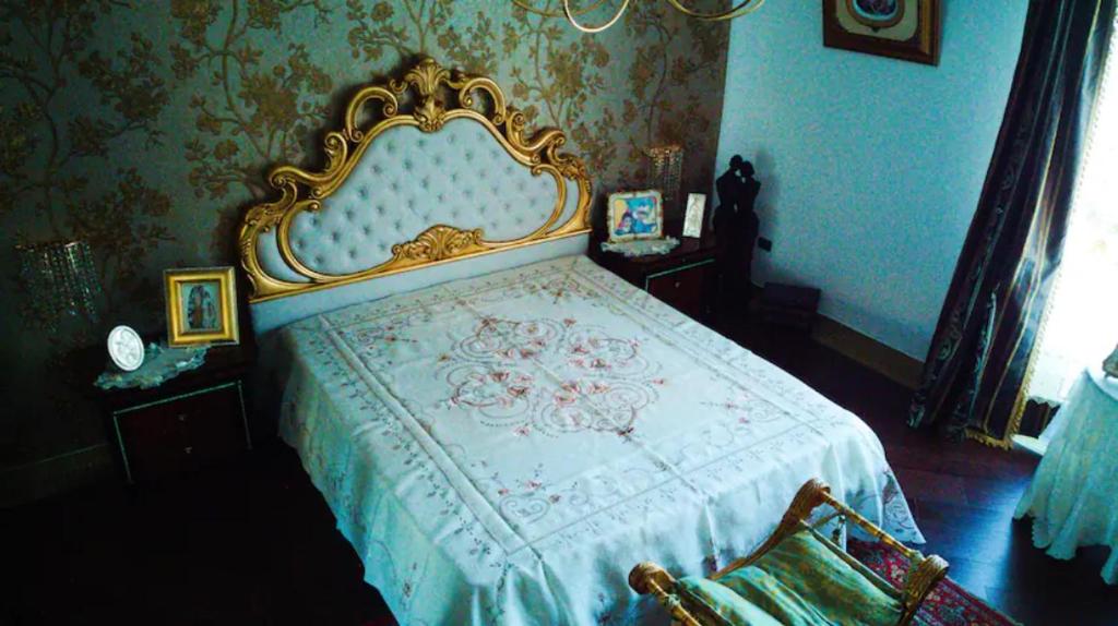 a bedroom with a king sized bed with a gold frame at Happy Journey in Santa Elisabetta