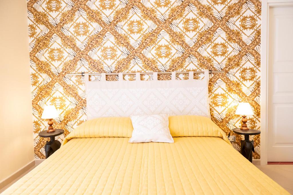 a bedroom with a yellow bed with a wall at Alloggio Turistico Porta di Poggio in Tuscania
