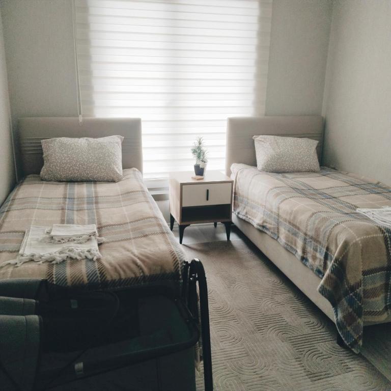 two twin beds in a room with a window at Ankara Esenboğa Airport Comfort Apart in Ankara
