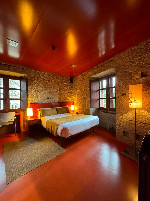 a bedroom with a bed in a brick wall at Pousada Torre Lombarda in Allariz