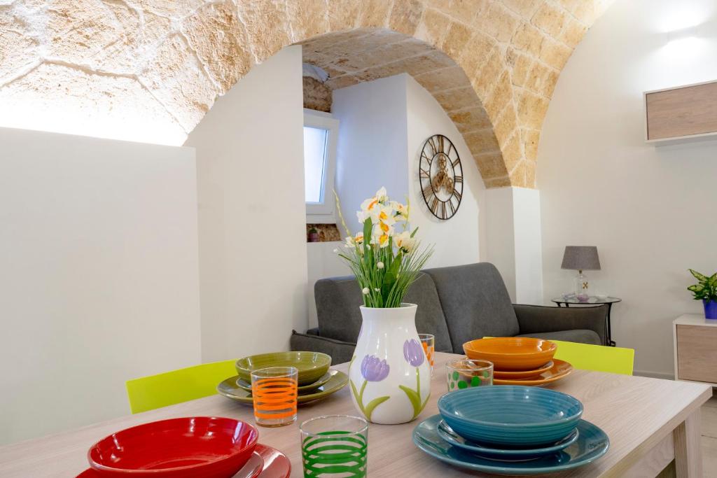 a dining room with a table with colorful dishes on it at Petit Maison Martini ' in Altamura