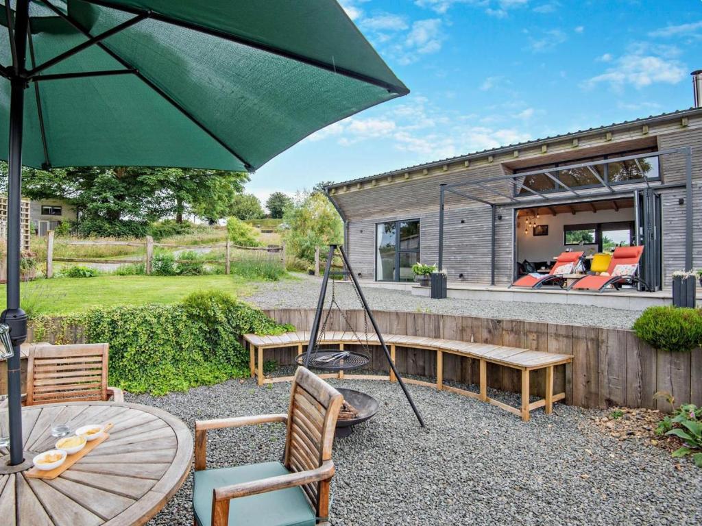 a house with a green umbrella and a table and chairs at 2 Bed in Llandrindod Wells oc-53193 in Llandrindod Wells