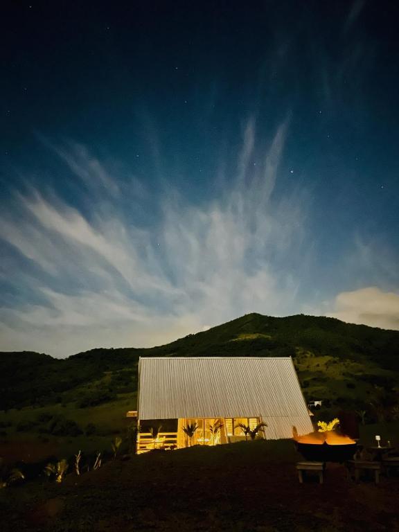 a building on a hill with a mountain in the background at The A Lodge in Grand Sable