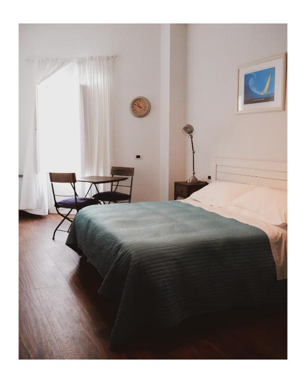 a bedroom with a bed and a table and a window at La Foresteria in Mola di Bari