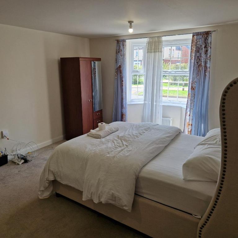 a bedroom with a large bed with a window at Nairn Way House in Kirby Muxloe