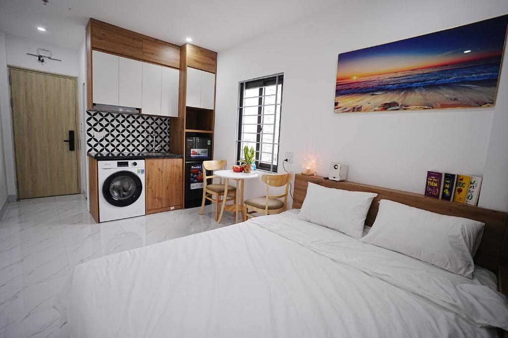 a bedroom with a large white bed and a table at Green West Lake Residence in Hanoi