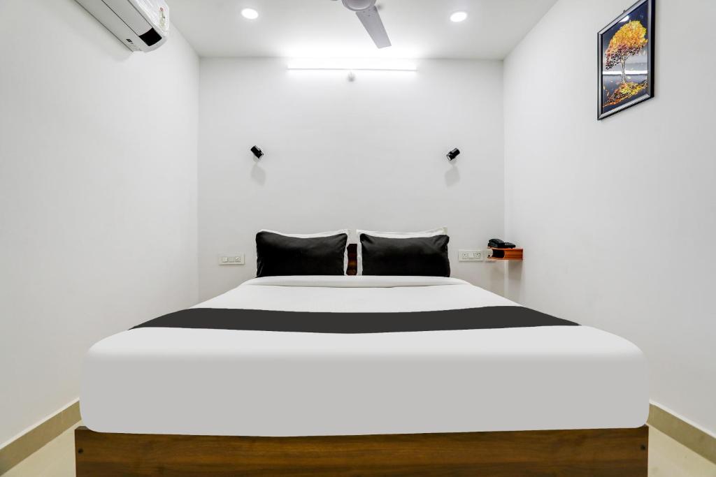 a bedroom with a large bed in a white room at Collection O De Alphabet Hotel in Hyderabad