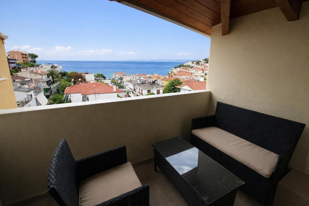 a balcony with two chairs and a view of the ocean at Delfini Hotel in Menídion