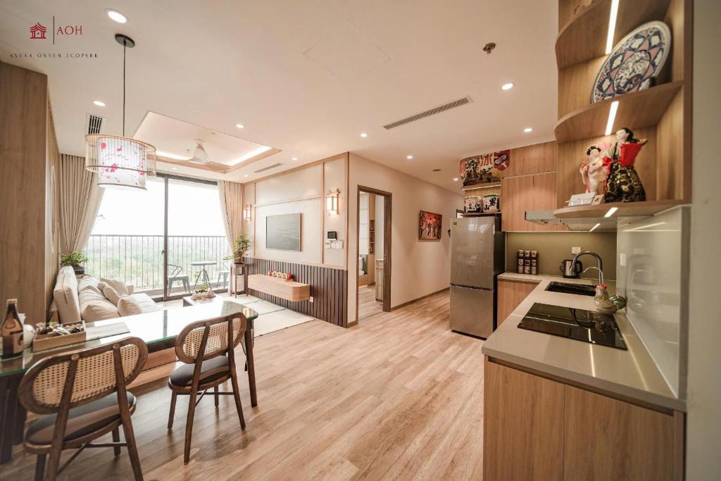 a kitchen and living room with a table and chairs at Maison de Ecopark - Onsen & Spa in Kim Quan