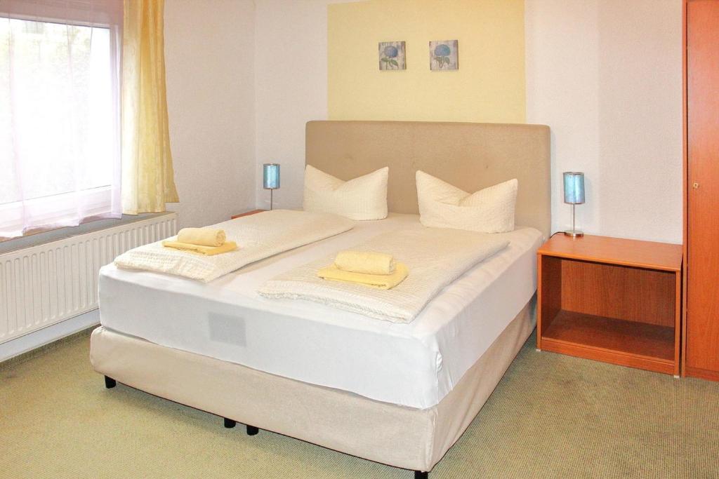 a bedroom with a bed with two yellow towels on it at Pension An der Kamske - DZ 3 in Lübbenau