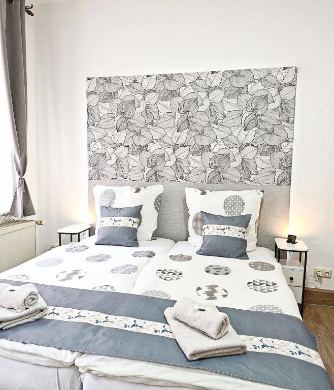 ein Schlafzimmer mit einem großen Bett mit einem floralen Kopfteil in der Unterkunft MonAppart in Gera