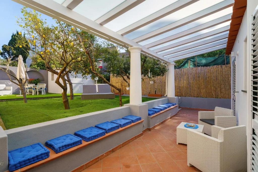 a patio with blue cushioned chairs and a pergola at La Perla House in Anacapri