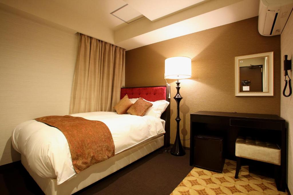 Postel nebo postele na pokoji v ubytování Centurion Hotel Grand Kobe Station
