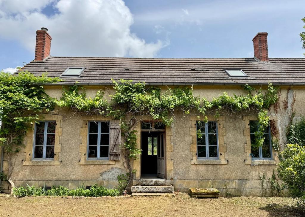 an old house with ivy on the side of it at Authentic house, absolutely quiet in Coust