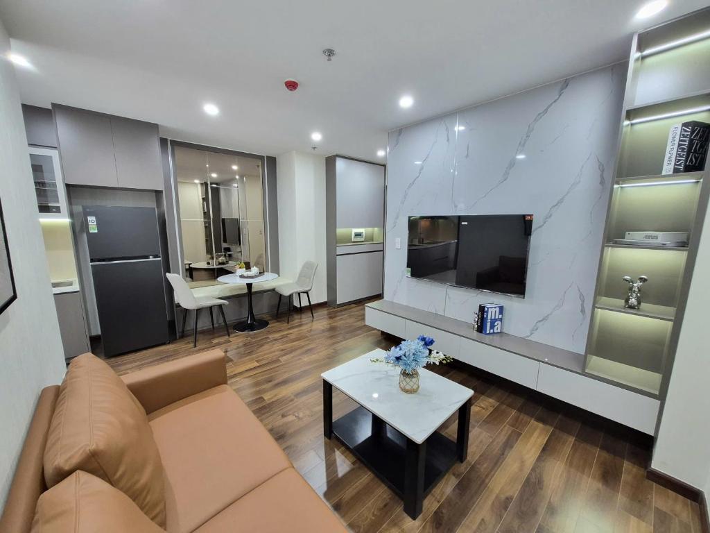 a living room with a couch and a tv at BenHill - serviced apartment-Binh Duong in Ấp Dừa