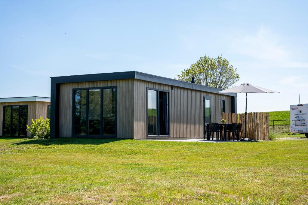 a small house with a table and an umbrella at Vakantiepark Lemmer in Lemmer