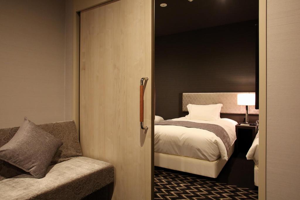 Postel nebo postele na pokoji v ubytování Centurion Hotel Grand Kobe Station