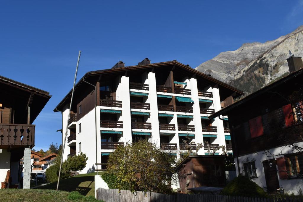 a large white building with a mountain in the background at Ferienwohnung Caluna in Lenz