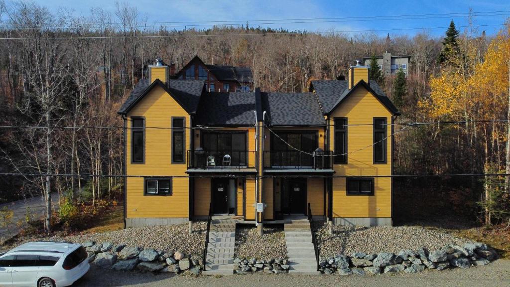 a yellow house with a car parked in front of it at Nature & Breathtaking View - Le Dumont - A in Saint-Philémon