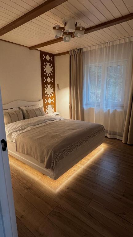 a bedroom with a large bed with a window at Gonta house in Skhidnitsa