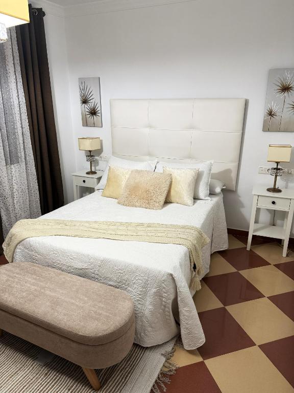 a bedroom with a large bed with a large headboard at Casa Miguelín in Montecorto