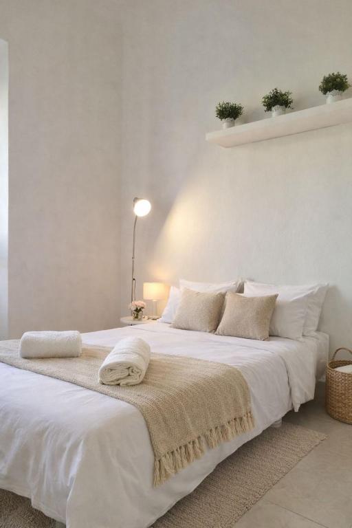 a white bedroom with a large white bed with towels on it at Appartamento Duomo-Monte Nero in Milan